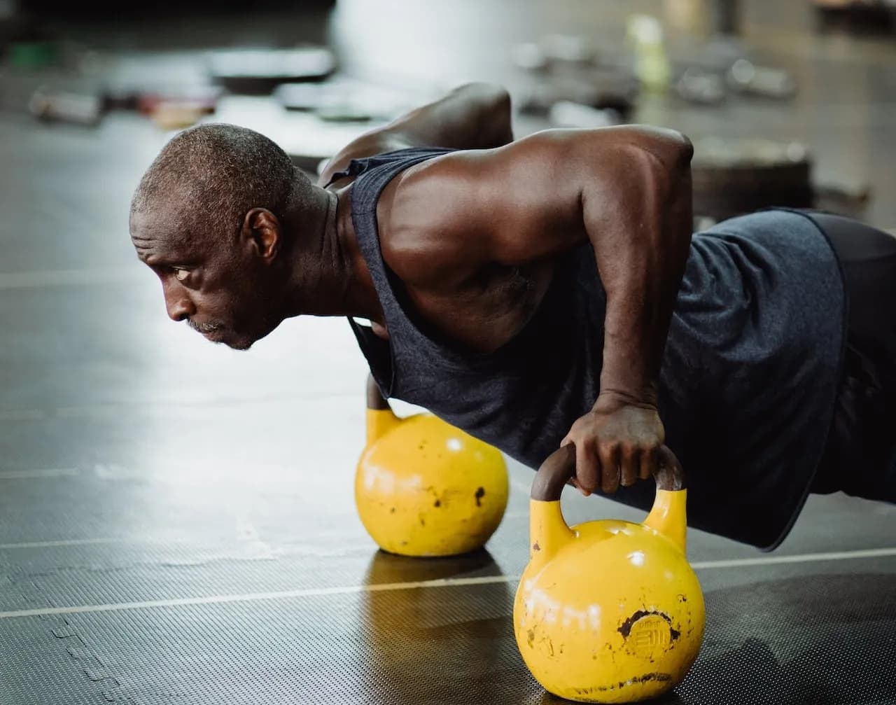 Man doing push ups on kettlebells